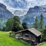 Grindelwald Switzerland mountain view overlooking a house with a paraglider